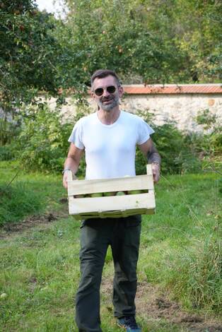 Photo d'ujne personne portant une cagette de pommes
