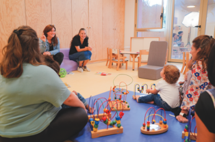 Photo d'enfants et adultes sur un tapis à la crèche