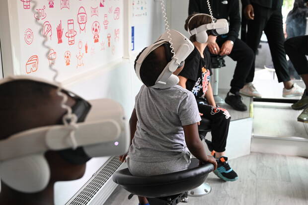 Photo d'enfants qui regardent dans un casque des images dans le VR bus