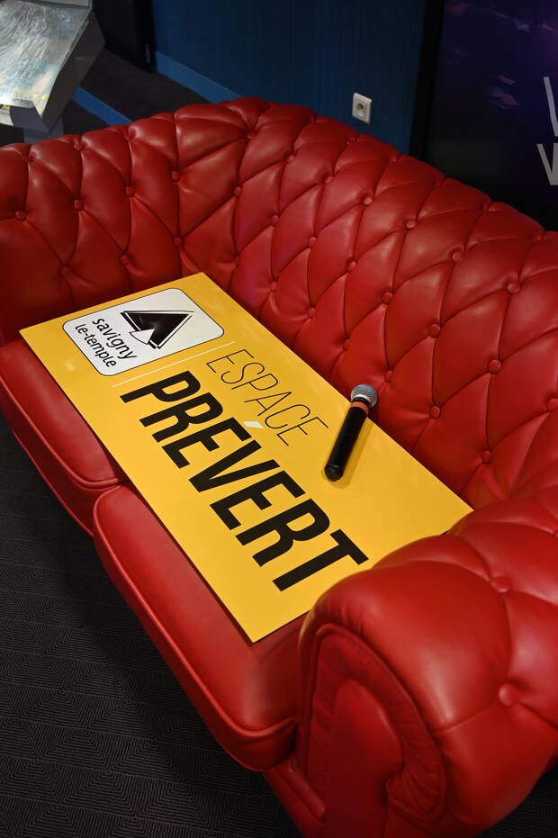 Panneau espace Prévert sur un canapé rouge