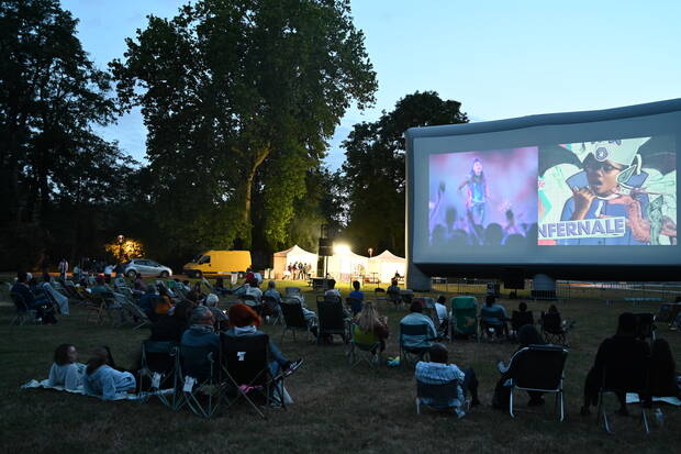 Photo de personne qui regarde le ciné pleine air